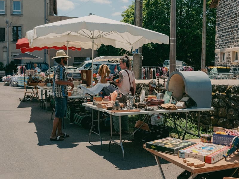 A shopper and a stallholder talking at an outdoor market.